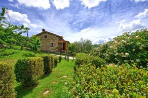 een stenen huis op een heuvel met een tuin bij Casa Margherita 2 by PosarelliVillas in Piegaio