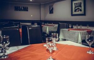 a row of wine glasses sitting on a table in a restaurant at Hotel New Derby in Constanţa