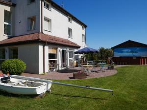 a boat on the grass in front of a house at Sloneczny Dom in Łeba