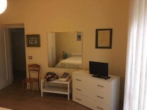 1 dormitorio con 1 cama y vestidor con espejo en I tulipani flat, en bedizzol