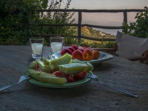 a plate of fruit on a table with two glasses of water at To Stefani tis Makrinas in Makrinitsa