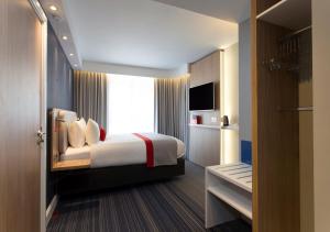 een slaapkamer met een bed en een groot raam bij Holiday Inn Express Edinburgh City Centre, an IHG Hotel in Edinburgh