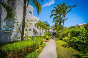 a walkway in front of a building with palm trees at Voile Bleue Boutique Hotel in Trou aux Biches