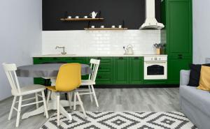 a kitchen with green cabinets and a table and chairs at Przystań Twórców in Słupsk