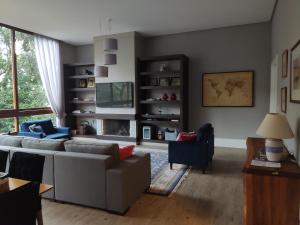 een woonkamer met een bank en 2 stoelen bij GRAMADO MINHA CASA Apartamento Premium - Centro in Gramado
