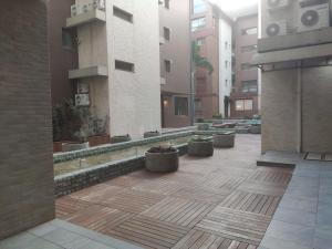 GRAMADO MINHA CASA Apartamento Premium - Centro في غرامادو: ساحة في مبنى به قدور من النباتات