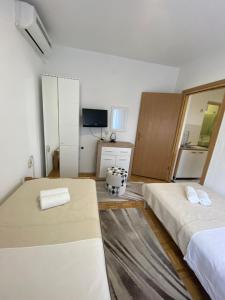 mały pokój z 2 łóżkami i telewizorem w obiekcie Apartman Iva w mieście Zadar
