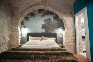 um quarto com uma cama grande numa parede de pedra em LA VIOLA.2 em Assis