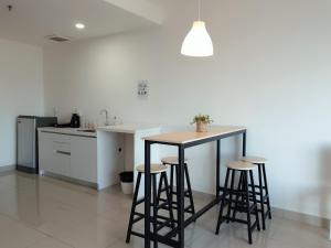 a kitchen with a counter with stools and a table at LetStay@Setia Alam/City Mall/Convention Centre in Shah Alam