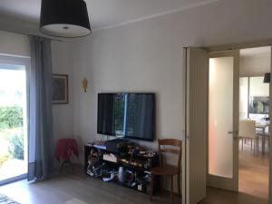 een woonkamer met een televisie en een tafel met een stoel bij I tulipani flat in bedizzol