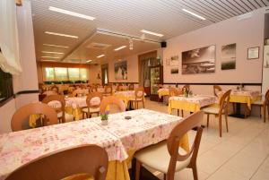 a dining room with tables and chairs and tablesktop at Hotel Firenze in Bellaria-Igea Marina