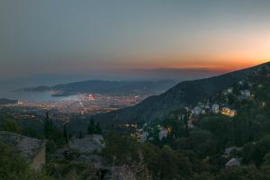 a view of a city from a mountain at sunset at To Stefani tis Makrinas in Makrinítsa