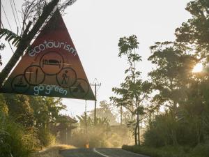 a sign on the side of a road with a train on it at Bukit Kembar Ecotourism in Gitgit