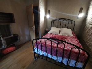 um quarto com uma cama com um edredão vermelho em Les Citounelles em Citou