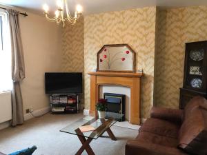 a living room with a fireplace and a mirror at Southwell in Southwell