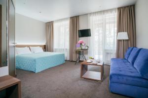 a bedroom with a blue bed and a blue couch at Vozdvizhenskoe Park Hotel in Serpukhov