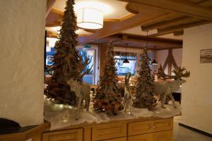 un comptoir avec des arbres de Noël au-dessus dans l'établissement Garni Hotel Wildanger, à Zöblen