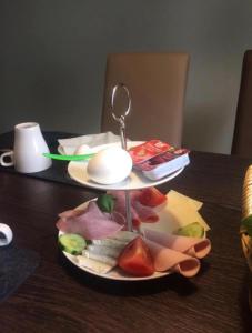 een bord eten op een tafel met een lepel bij Hotel Unter den Linden in Kierspe