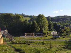 a view of a farm with a playground and a yurt at cararetro , caravane chauffée et climatisée in Saint-Sylvain-Bellegarde