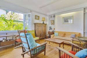 ein Wohnzimmer mit einem Sofa und einem Tisch in der Unterkunft Charming Basque villa with garden - Bayonne - Welkeys in Bayonne