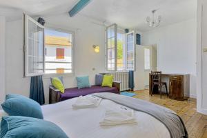 1 dormitorio con cama, sofá y ventanas en Charming Basque villa with garden - Bayonne - Welkeys, en Bayona