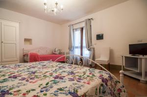 een slaapkamer met een bed en een rode bank bij Agriturismo Oasi Torre Del Colle in Bevagna