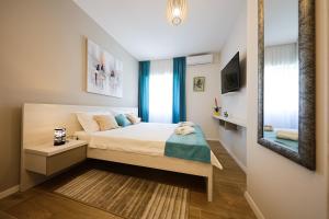 ein kleines Schlafzimmer mit einem Bett und einem Spiegel in der Unterkunft Apartment Ventum in Zadar