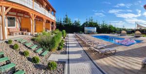 a resort with a pool and chairs and a building at Złociste Zacisze in Bobolin