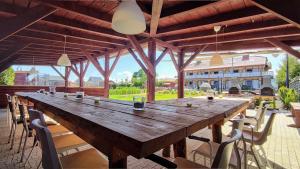 a large wooden table on a patio with chairs at Złociste Zacisze in Bobolin +62 photos