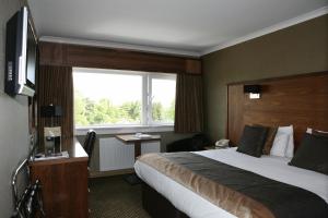 a hotel room with a bed and a window at Park Hotel in Falkirk