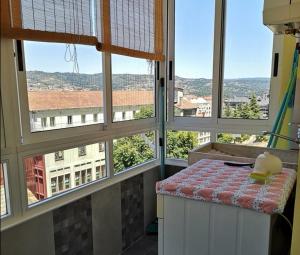 Cette chambre dispose de fenêtres et d'un comptoir avec une table. dans l'établissement Piso Auditorio Ourense, à Ourense