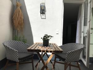 a wooden table and two chairs on a patio at SYBILLE KUNTZ Weingut Gästehaus in Lieser