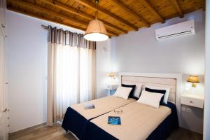 a bedroom with a bed with a blue and white comforter at Filoxenia Apartments in Ornos