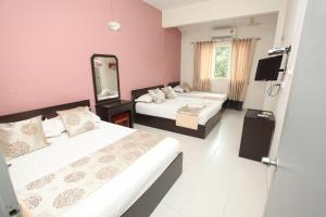 a hotel room with two beds and a mirror at WARNI 45 Whole Or Room in Muar