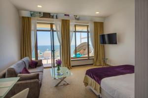 a hotel room with a bed and a view of the ocean at Hotel Panorama De Luxe in Odesa