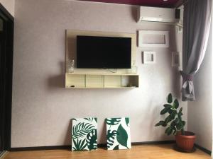 a living room with a television on a wall at Апартаменты с прекрасным видом на море в Актау in Aktau