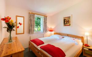 a bedroom with a bed and a vase of flowers on a table at Appartements im Park in Krumpendorf am Wörthersee