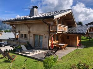 a log house with a deck and a balcony at Chalet Nanook in Notre-Dame-de-Bellecombe