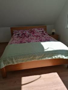 a bedroom with a bed with a red and green comforter at Domek na Kaszubach nad Jeziorem in Kłodno