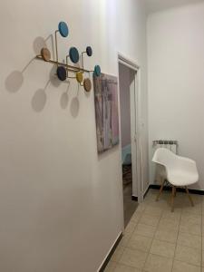 ヴァラッツェにあるHotel Spot Varazzeの白い椅子と壁画が備わるお部屋