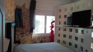 a bedroom with a bed and a window and a television at Vista mare in Torre Lapillo
