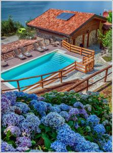 - une piscine en face d'une maison fleurie dans l'établissement Fantastica Casa Poppo, à Bellano