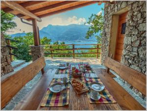 a table on a deck with a view of the mountains at Fantastica Casa Poppo in Bellano