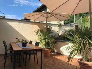 a table and chairs with an umbrella on a patio at SYBILLE KUNTZ Weingut Gästehaus in Lieser +28 photos