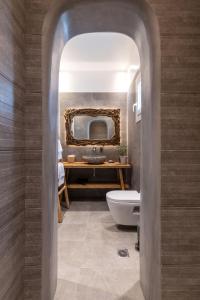 uma casa de banho com um lavatório, um WC e um espelho. em Secret Garden Apartments em Míconos
