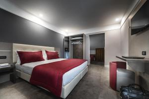 a bedroom with a large bed with red pillows at Hotel Varese in Rome