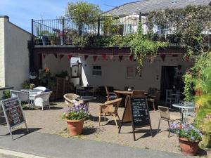 a restaurant with tables and chairs and signs in front of it at Two Moors Retreat in Witheridge