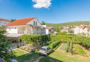 una casa con una furgoneta estacionada en un patio en Apartmani Mlinar9 #1 en Gornji Karin