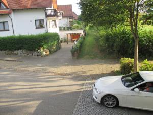 un coche blanco estacionado al lado de una calle en Ferienwohnung Kiruga en Kippenheim