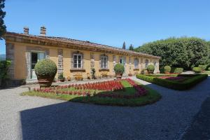 a house with a garden of flowers in front of it at Villa Luisa in Lucca